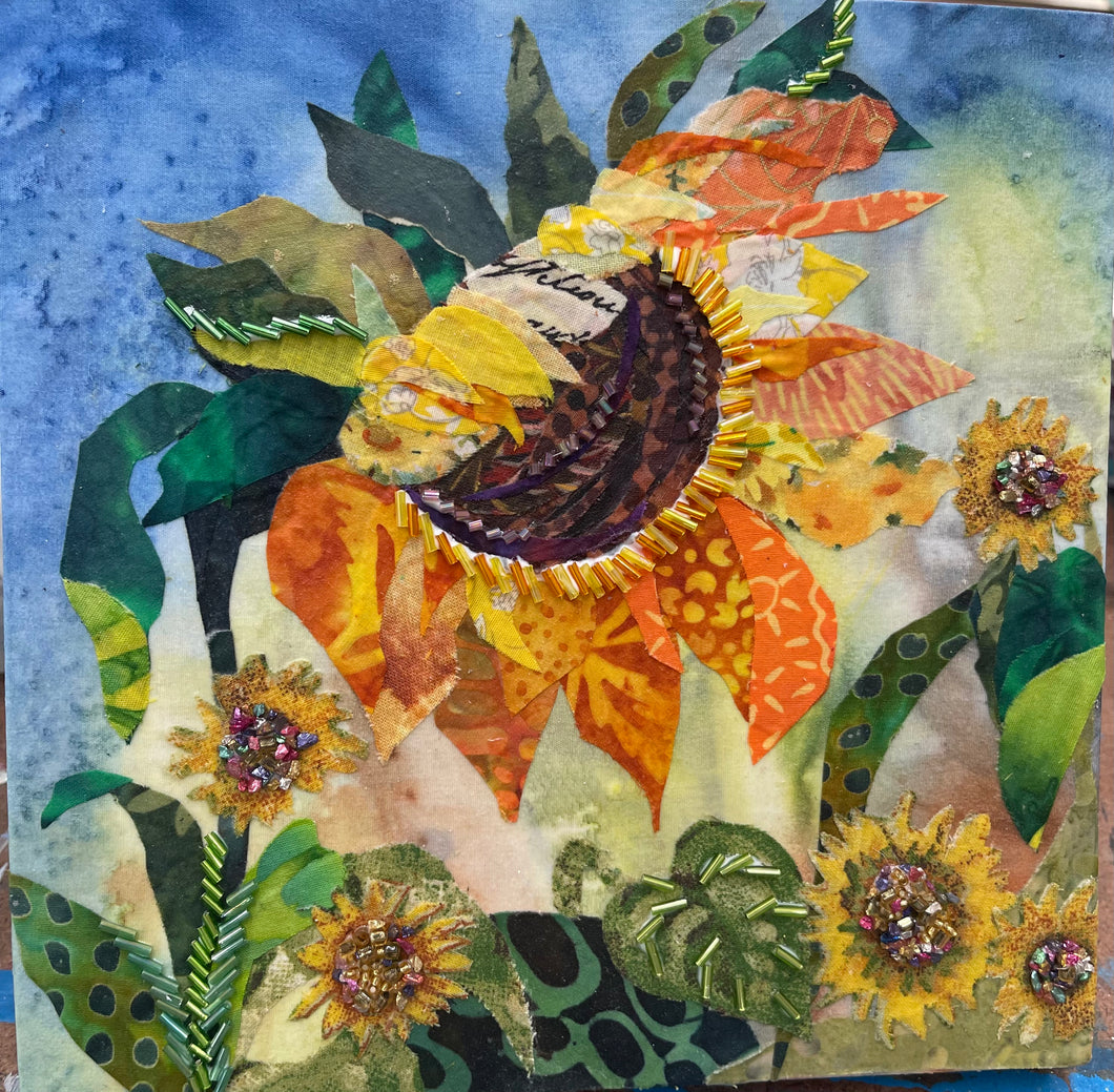 Sunflower-inspired floral wall art in fabric mixed media with layered petals, botanical design, and dimensional textile detail