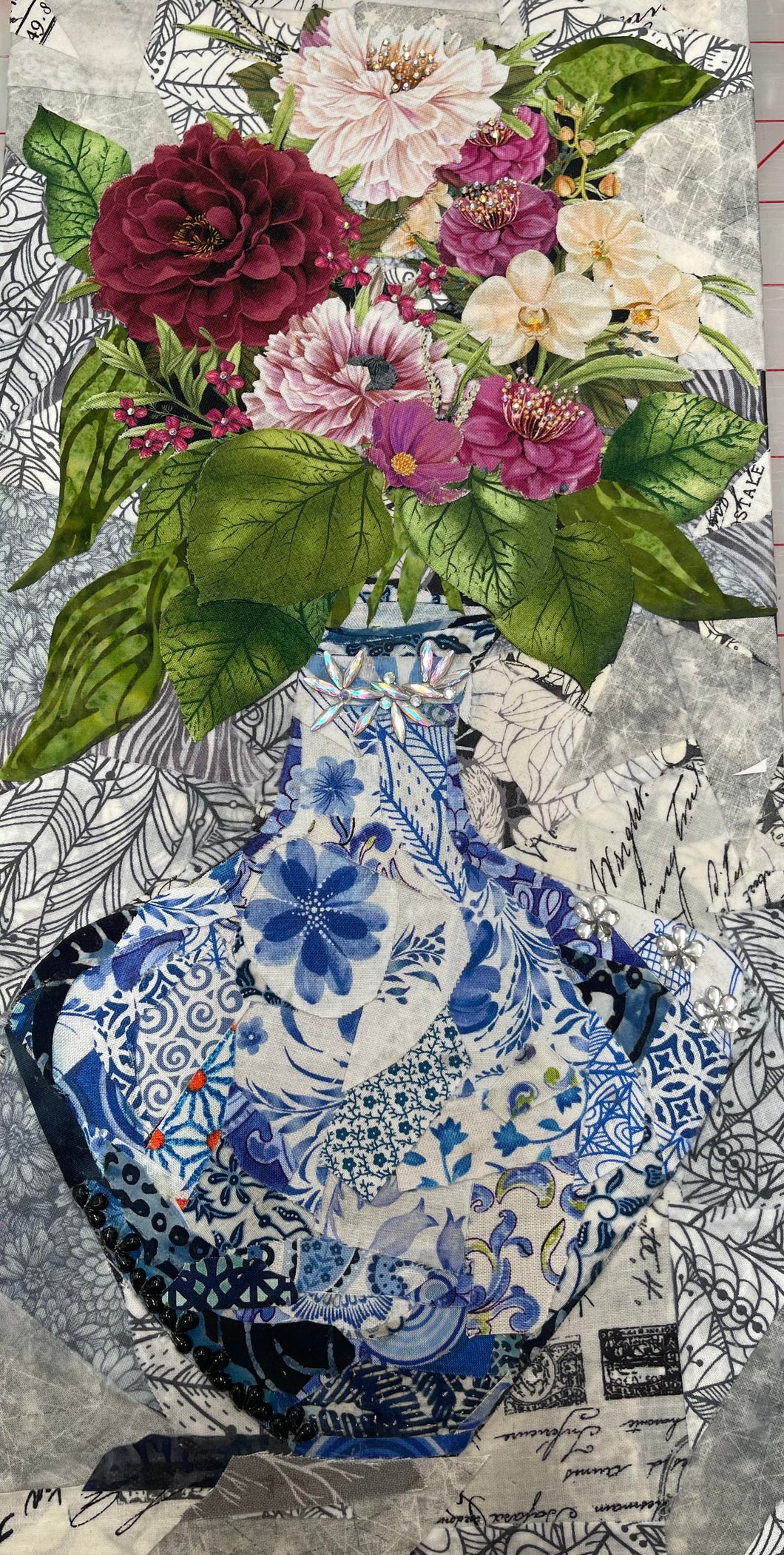 Floral still life wall art in fabric layered collage arrangement and blue Chinoiserie patterned vase on textured background 