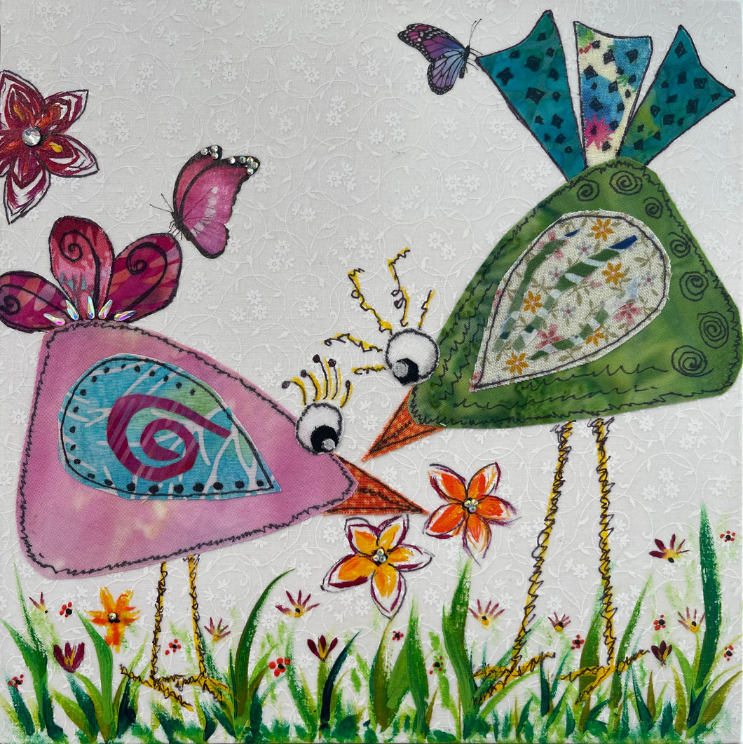 Whimsical textile bird art showing two colorful birds facing each other with flowers and butterflies in a playful garden scene