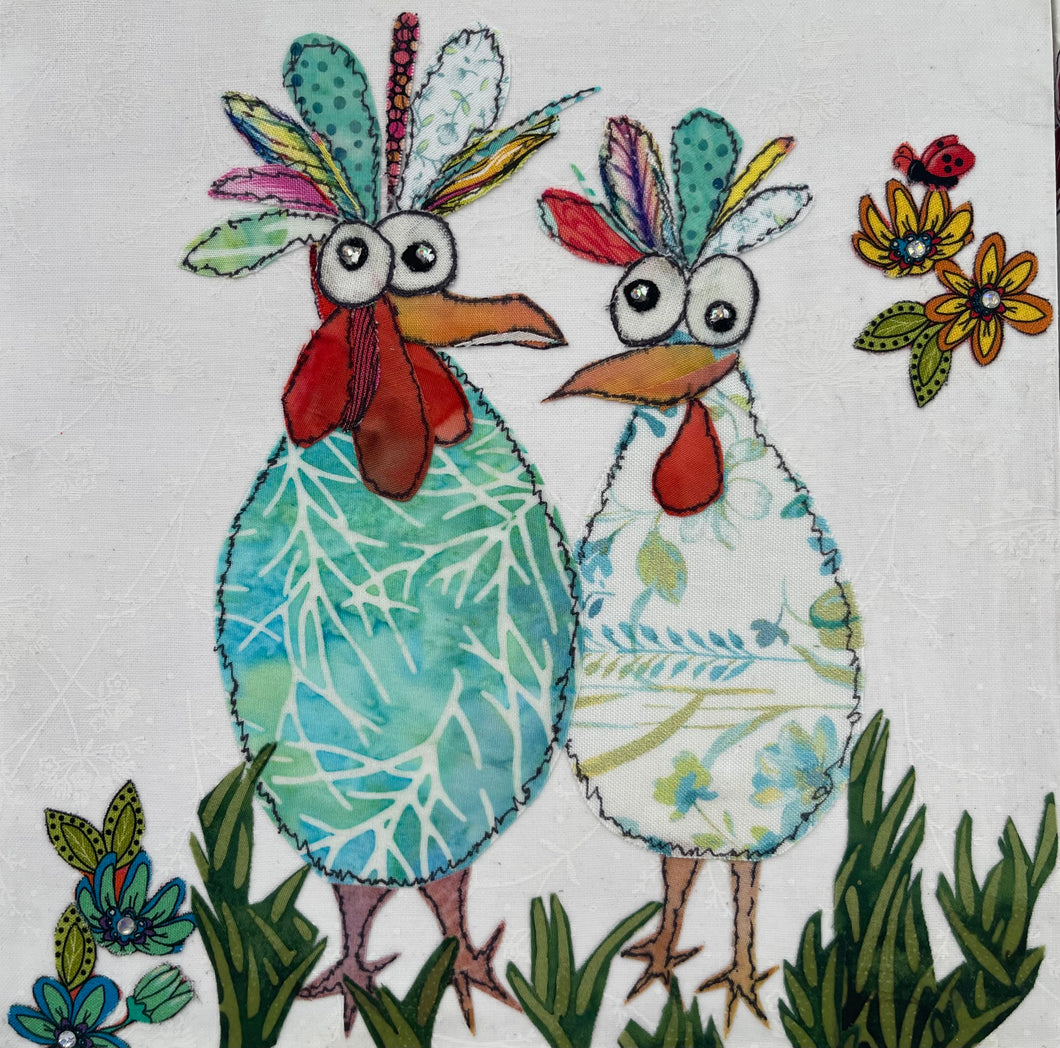 Whimsical bird textile art showing two colorful birds standing in grass with floral accents in a playful scene