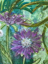 Close-up of a decorative purple flowers  with crystal centers and green leaves on a textured surface