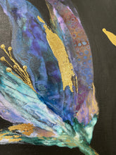 Close-up of a colorful abstract painting with gold accents on a dark background