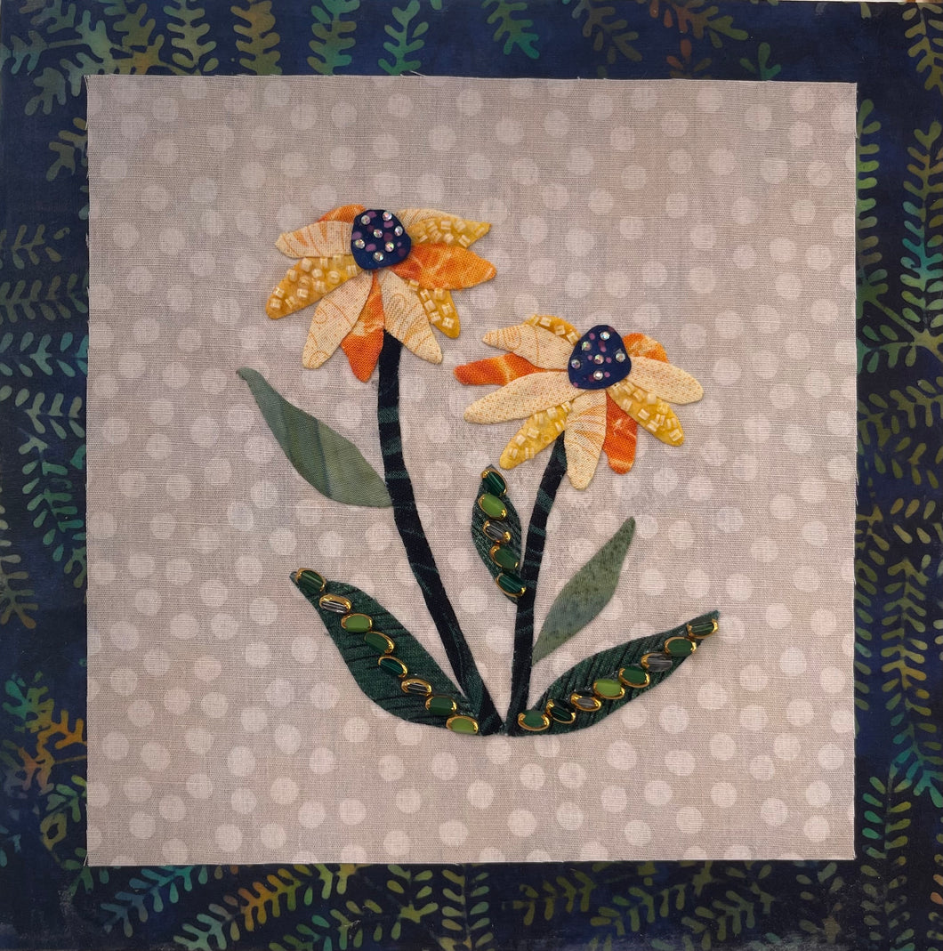 8 x 8 fabric collage artwork featuring two yellow flowers with beaded green leaves made from inherited textiles