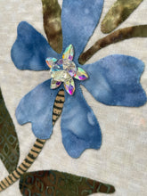 Close-up of blue fabric flower showing crytstals and textured leaves