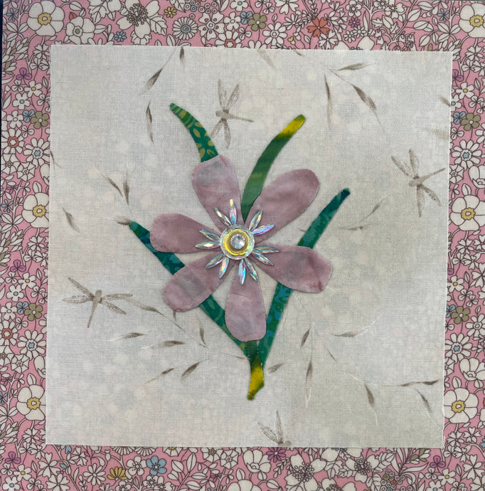 8 x 8 fabric collage artwork featuring a soft blush flower with a crystal center and green stems made from inherited textiles