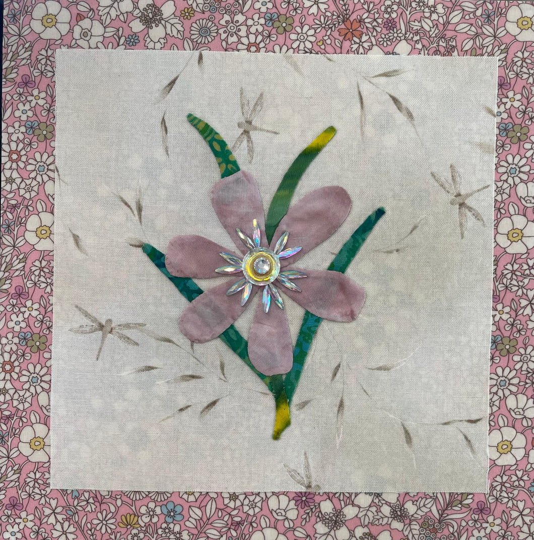 8 x 8 fabric collage artwork featuring a soft blush flower with a crystal center and green stems made from inherited textiles