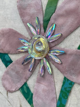 Close-up decorative flower with crystal center on fabric background