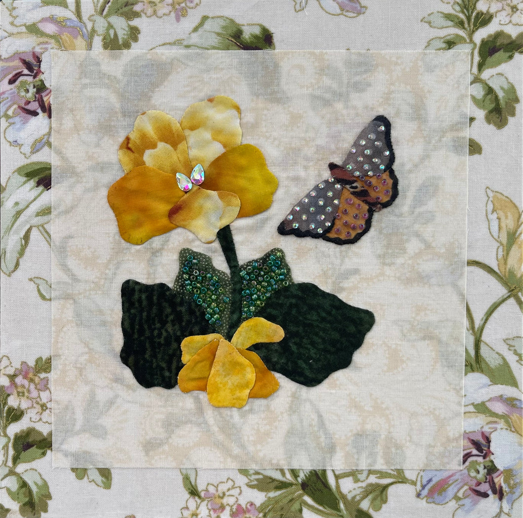 8 x 8 fabric collage artwork featuring yellow flowers with bead embellishments and a butterfly made from inherited textiles on neutral background