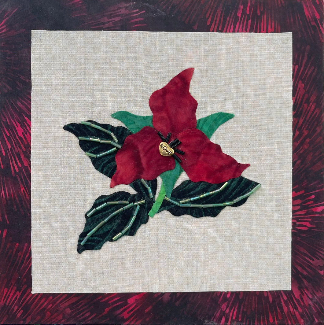 8 x 8 fabric collage artwork featuring a deep red flower with a gold heart center and green beaded leaves made from inherited textiles
