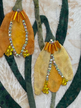Close-up of bell floral design and crystal bead details on a textured fabric background