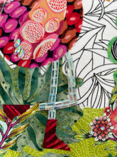 Close-up of a colorful fabric with floral and abstract patterns.