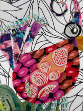 Close-up colorful fabric art piece with a stylized bird design on a white and balack patterned background
