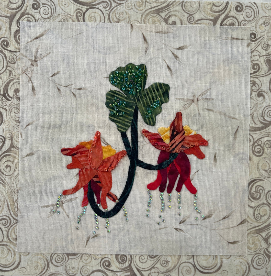 8 x 8 fabric collage artwork featuring red and orange flowers with cascading bead details and green leaves made from inherited textiles