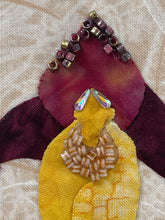 Close-up of top of bloom showing beading and crystals. Bloom is burgundy and yellow
