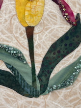 Close-up of a floral fabric design with beads on a beige background