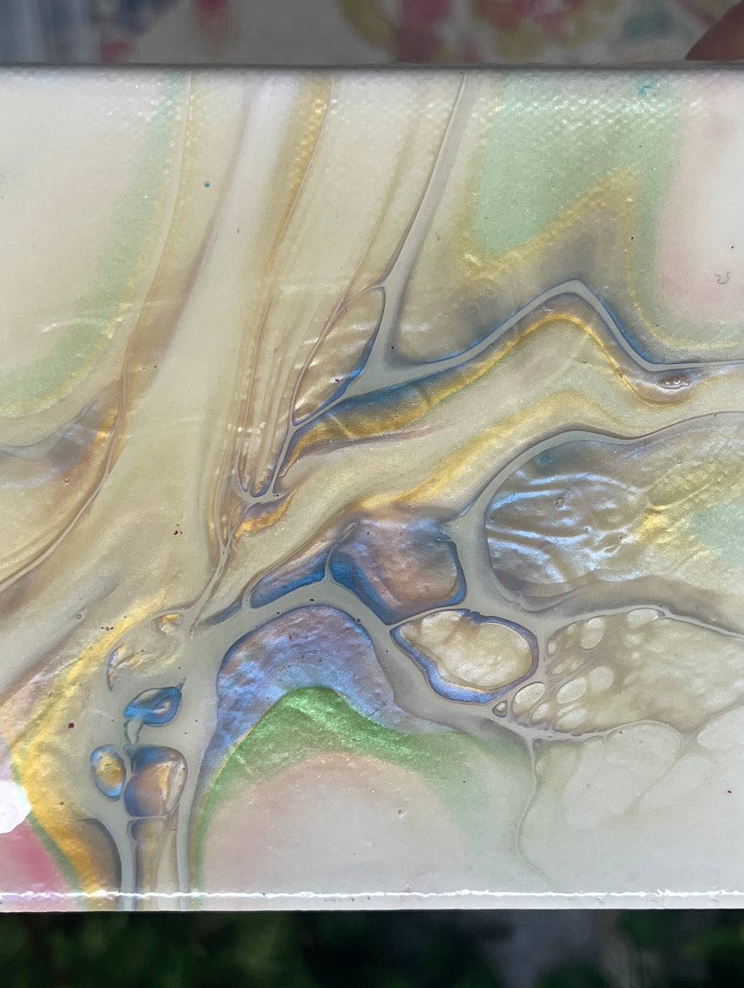 Shifting Current abstract resin artwork with flowing luminous pearl, blue, gold, and green pigments in a gold floating frame.