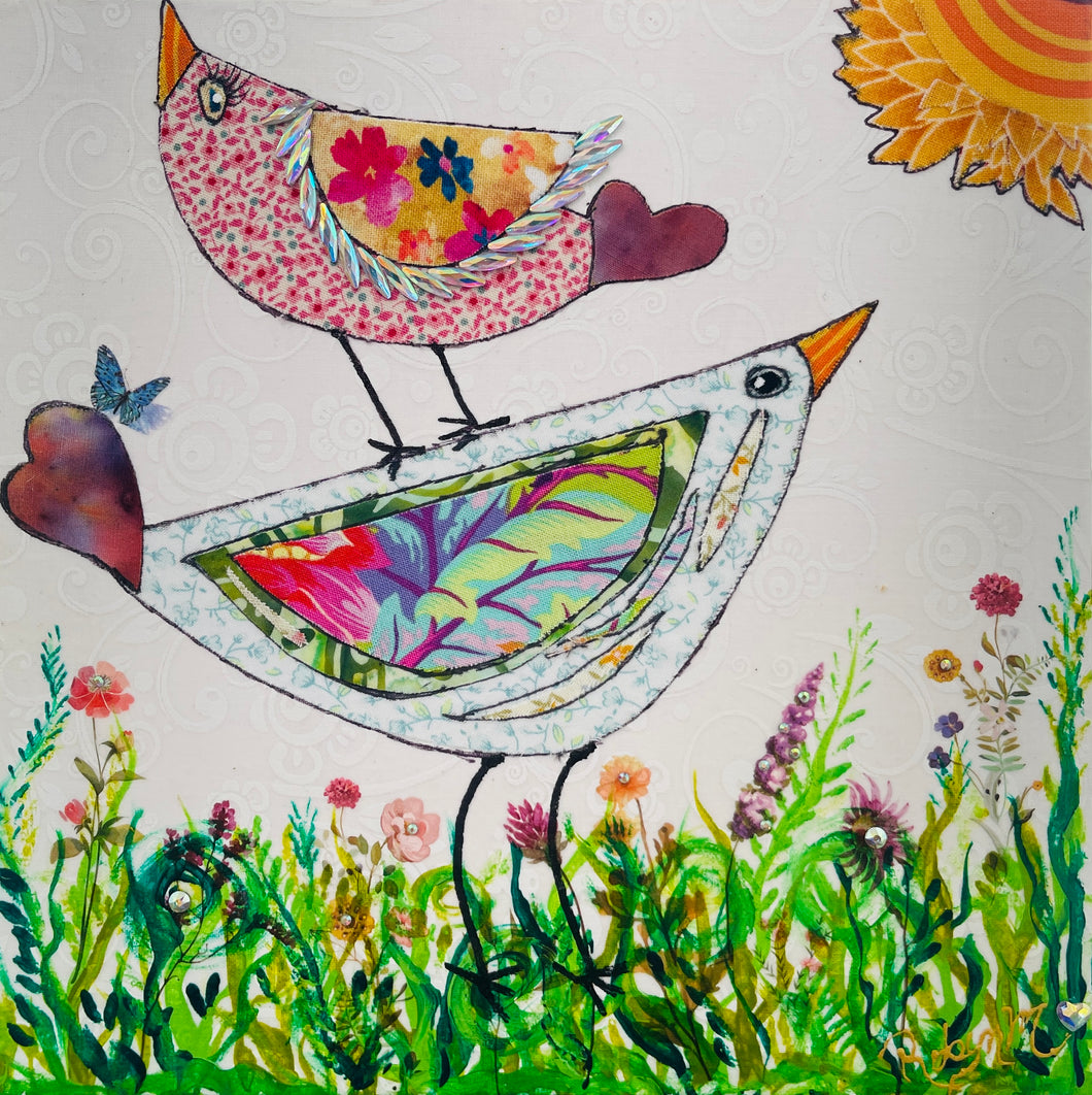 Whimsical bird artwork made with layered fabric and mixed media, featuring uplifting bird forms in soft neutral and warm tones in a grassy flower field