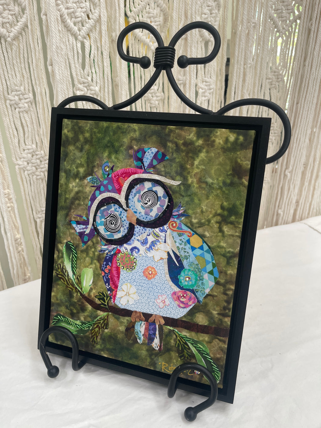Original whimsical owl fabric artwork 8x10 inches, patchwork owl in blue lavender teal magenta coral fabric with Czech glass bead eye rings spiral center eyes Swarovski crystal flower details purple fabric crown Czech glass bead leaf branch, deep olive brown batik background, birch panel, Whimsical Companions Collection, Robyn Moore Arts