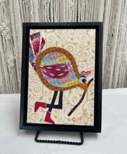 Whimsical fabric collage bird with colorful patterned body holding a walking stick, set against a soft swirling background
