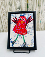 Whimsical red fabric collage bird with raised wings, green legs, and black boots on a softly illustrated background