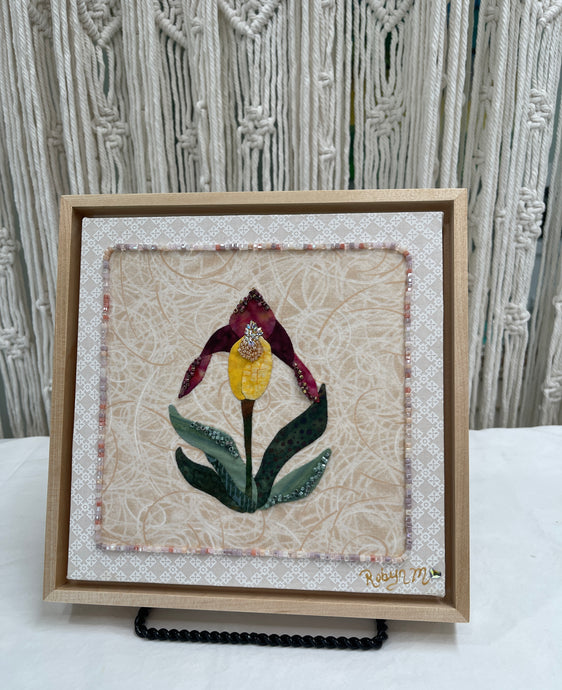 8 x 8 fabric collage artwork featuring a single yellow and burgundy flower made from inherited textiles with bead embellishments on neutral background
