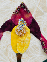 Close-up of top of bloom showing beading and crystals. Bloom is burgundy and yellow