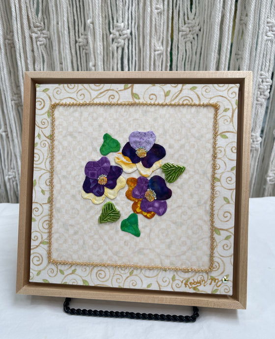 8 x 8 fabric collage artwork featuring a cluster of purple and cream flowers with beaded centers made from inherited textiles