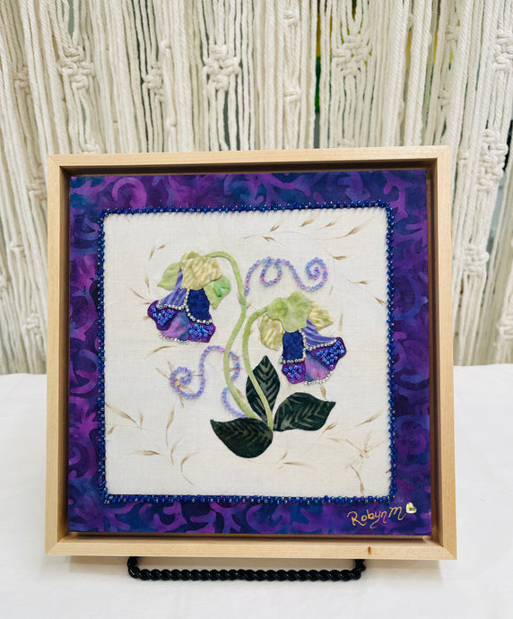 Fabric design of purple flowers on a textured white fabric with a purple patterned background.