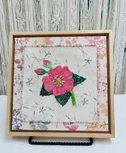 Coral pink fabric collage flower with Swarovski crystal center on neutral textile background, mixed media botanical artwork on birch panel