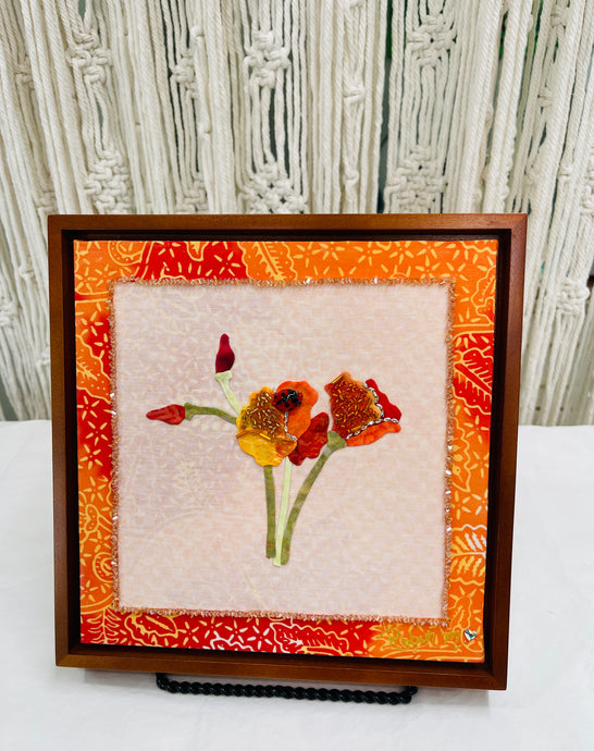 8 x 8 fabric collage artwork featuring orange and red flowers with bead embellishments and a small ladybug detail made from inherited textiles