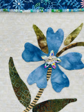 Close-up of blue fabric flower showing Swarovski crytstals and textured leaves