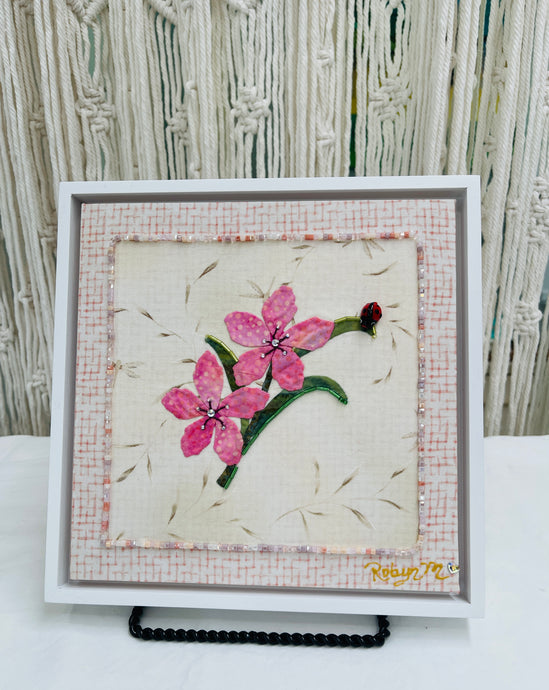 8 x 8 fabric collage artwork featuring two pink flowers with crystal centers and a small ladybug detail made from inherited textiles
