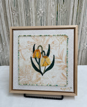 Yellow and gold bell-shaped fabric flowers with beadwork and Swarovski crystal detail on a soft neutral textile background, mounted on an 8x8 panel