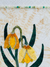 Close-up of bell floral design and Swarovski crystal bead details on a textured fabric background