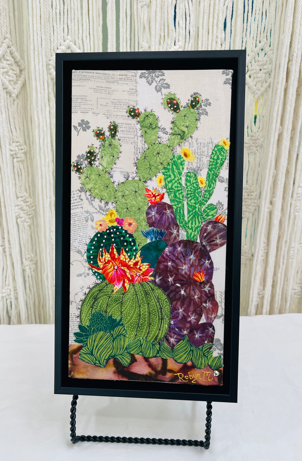 Original flowering cactus fabric artwork 6x12 inches, tall columnar green cacti dramatic dark spotted cactus with vivid pink orange blooms purple prickly pear Swarovski crystals ink pen spine detail, vintage toile botanical text background warm brown ground, birch panel, Floral Botanical Collection, Robyn Moore Arts