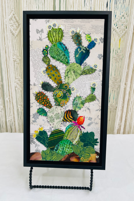 Original cactus fabric artwork 6x12 inches, prickly pear cactus in layered patterned batik fabrics teal gold olive orange with Swarovski crystal white flower centers ink pen spine detail single orange red bloom, vintage toile botanical text background warm brown ground, birch panel, Floral Botanical Collection, Robyn Moore Arts
