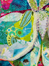 Close detail of gold foil wing edges and Czech glass bead and Swarovskincrystal embellishment on original fabric luna moth artwork Luna in Bloom by Robyn Moore Arts, showing jewel like surface detail against sage and celadon batik fabric wings