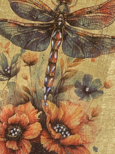 Close-up of a hand-layered dragonfly on gold leaf, with crystal accents along its body, part of the Golden Hour Collection.