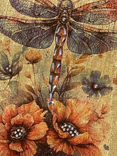 Close-up of a hand-layered dragonfly with dark, detailed wings on gold leaf, with crystal accents along its body.