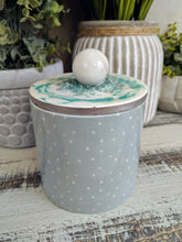 green and white polka dot candle canister with teal white sphere lid