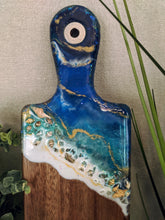 close up abstract ocean resin cheese board with shells and fire glass