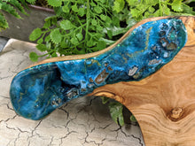 close up olive wood cheese board with teal green gold resin and fire glass