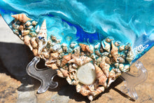 close up ocean heart with shells blue teal white