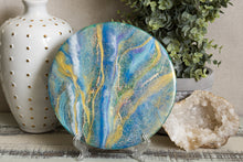 abstract fluid acrylic round painting with texture and vibrant blue colors and glitter